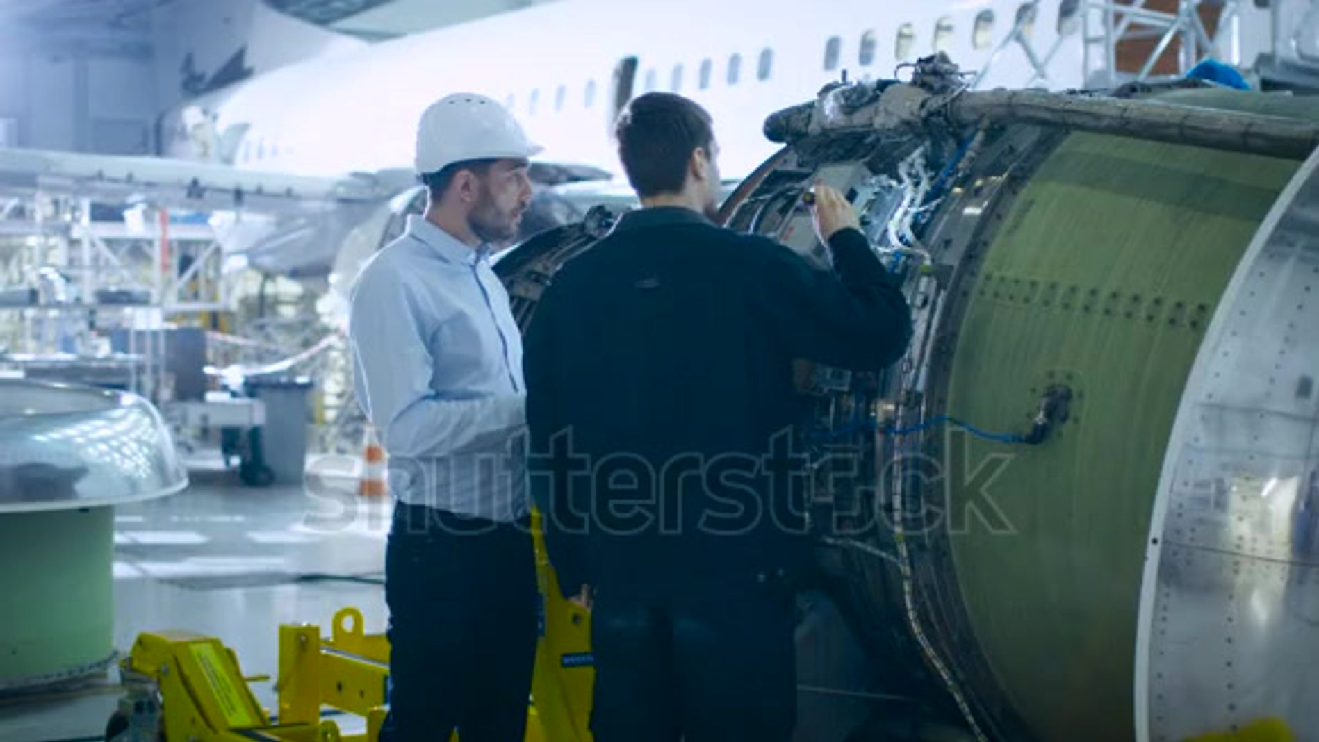 stock-footage-aircraft-maintenance-engineer-and-mechanic-inspecting-and-working-on-airplane-jet-engine-in-hangar